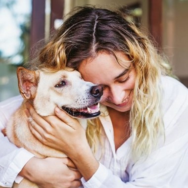 woman happily hugging dog